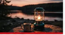 Lantern and camping equipment at dusk